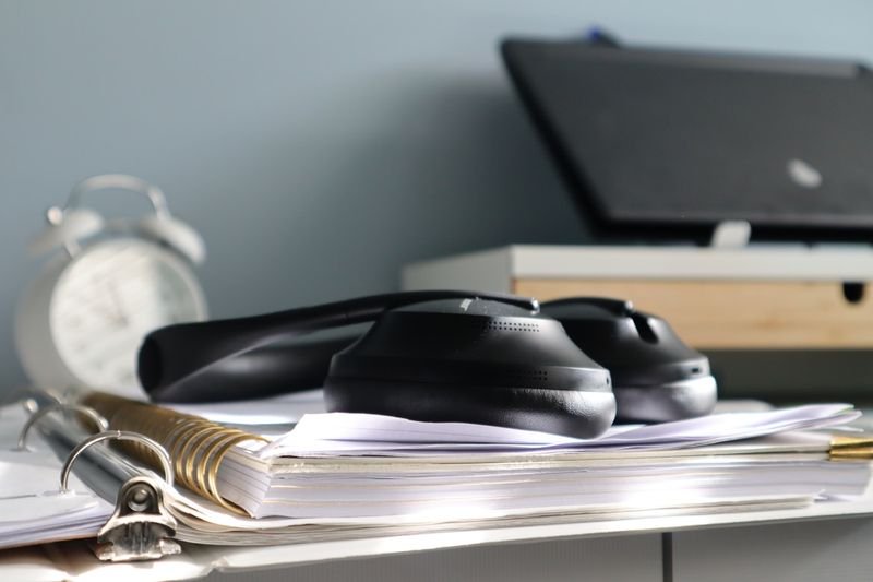 Desk with papers and headphones illustrating do your homework and do your work in English
