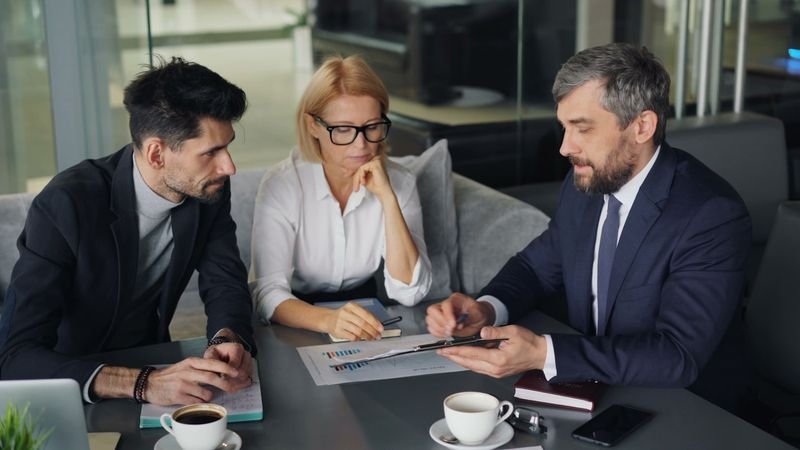 Colleagues in a meeting telling each other information in English