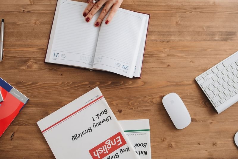 Student studying English phrasal verbs at a desk with a textbook