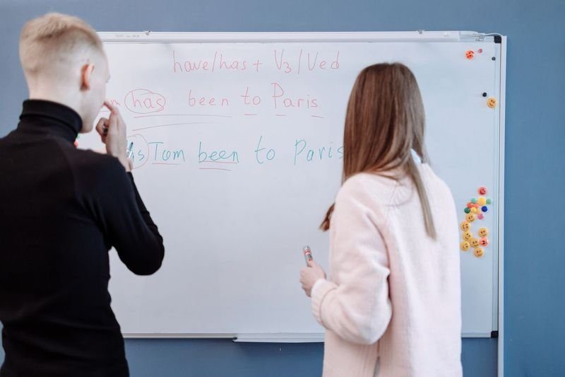 students learning English question tags grammar on whiteboard