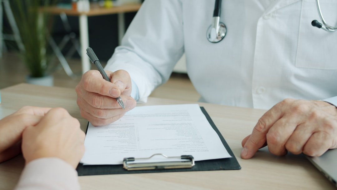 Medic in uniform is ticking symptoms in patient's medical records during appointment in clinic talking to patient sick woman.