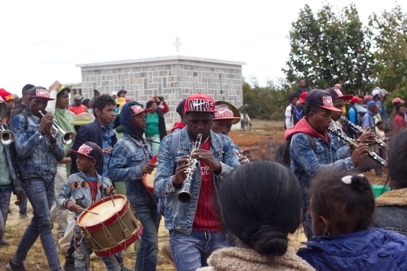 A traditional brass band performing outdoors before a crowd at a cultural heritage celebration