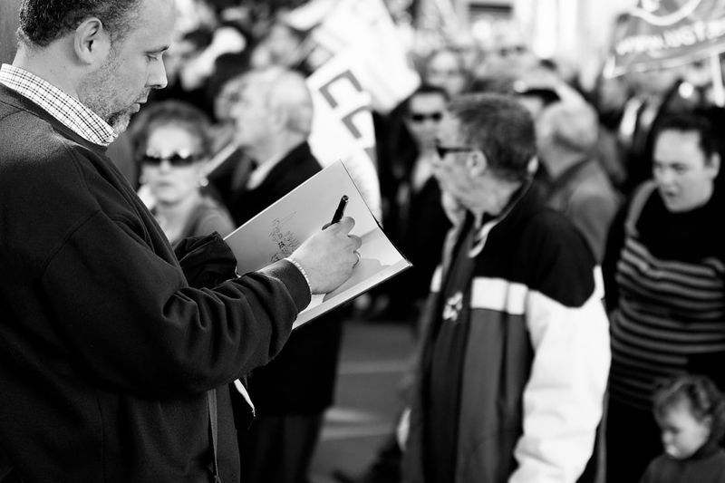 pass out meaning — distributing papers in a group setting