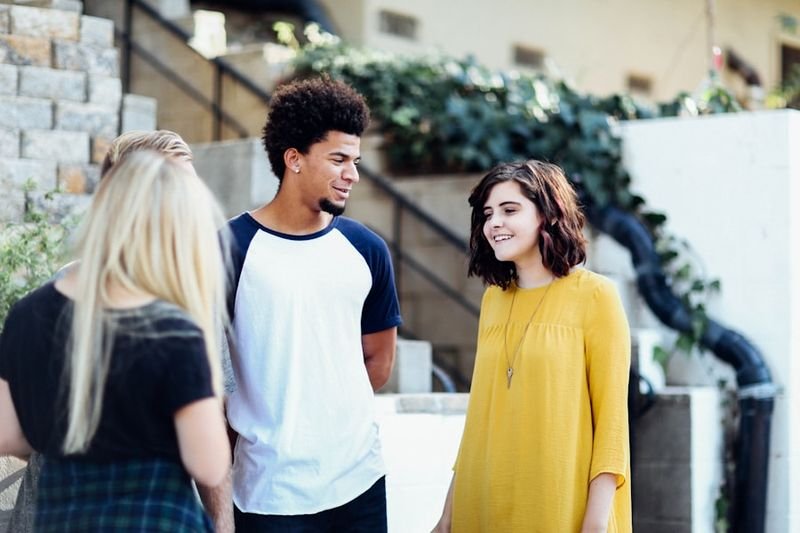 Personality adjectives in English - diverse group of young people talking outdoors