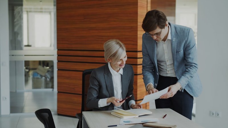 phrasal verbs with make — two business professionals reviewing reports together in an office