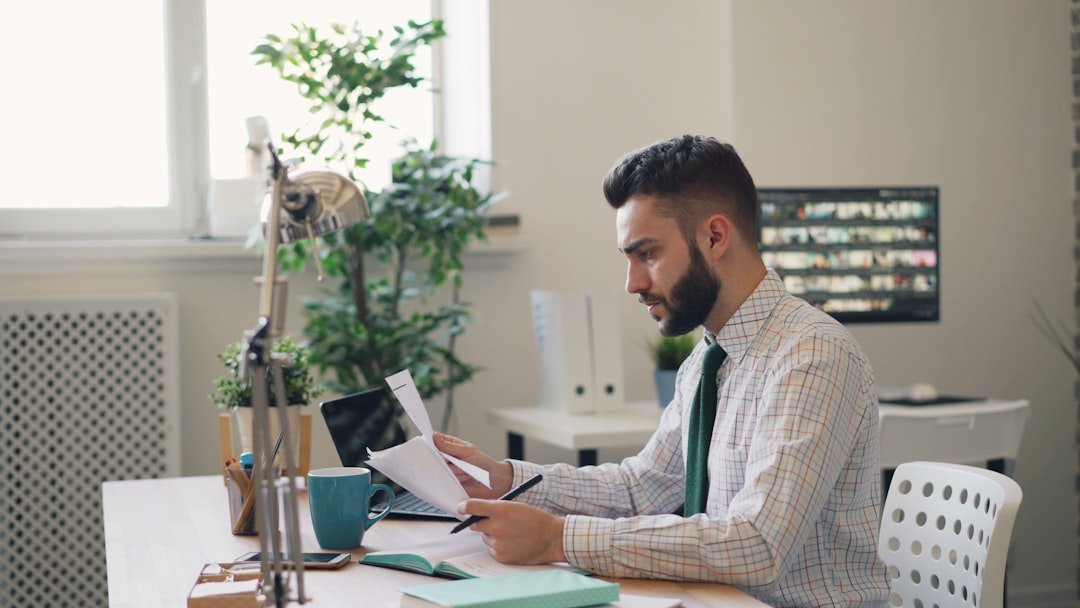 Stressed guy reading business contract shaking head throwing pen in office