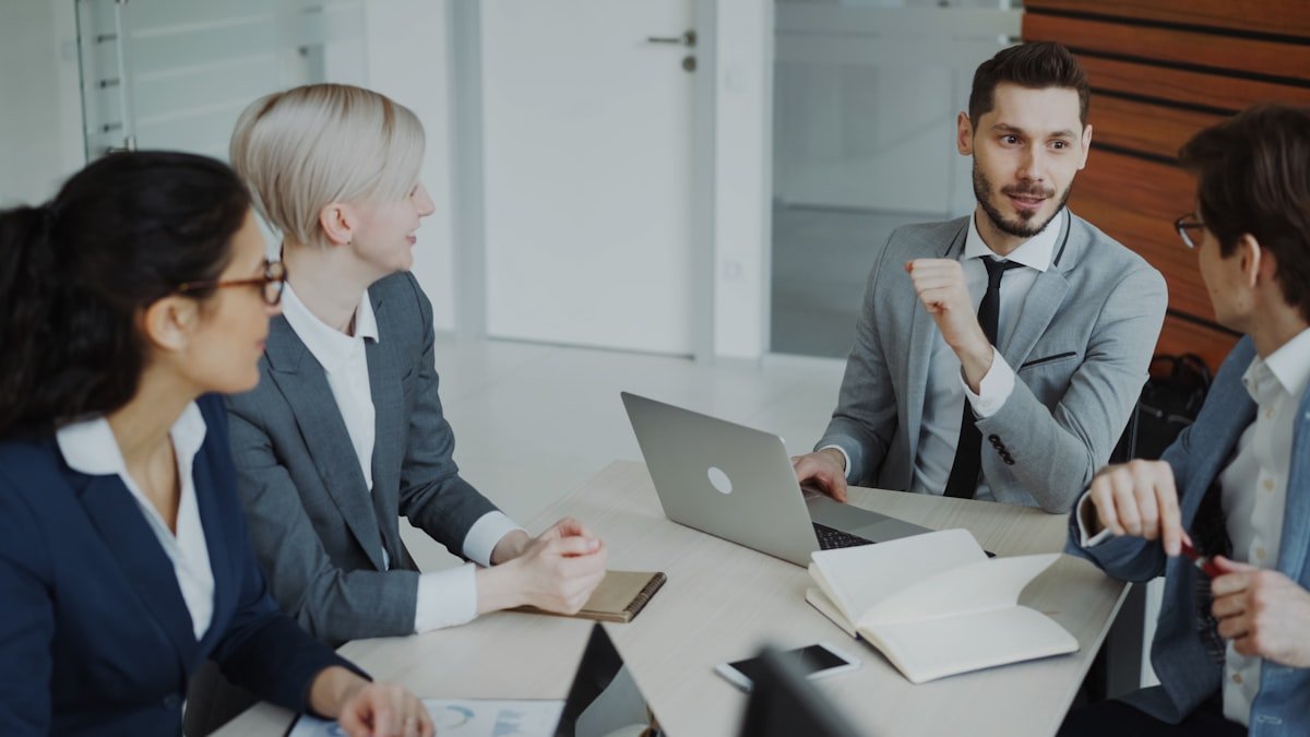Phrasal Verbs with MAKE — business professionals discussing English phrases in a modern office