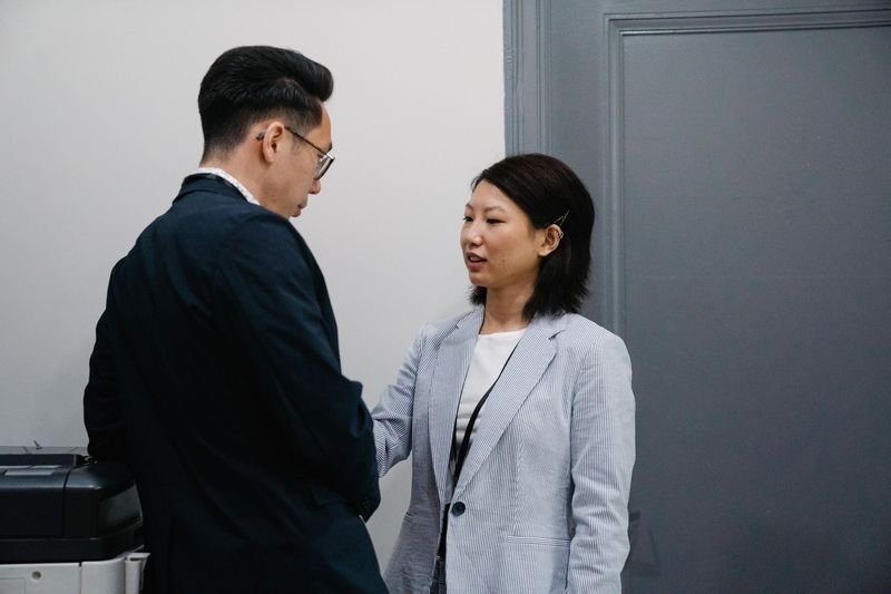 Two professionals having a respectful conversation about workload in an office