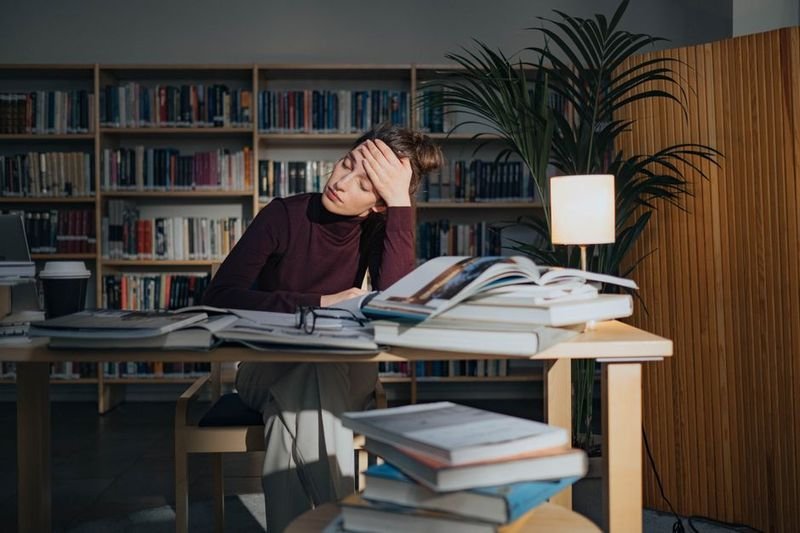 Pull an all-nighter idiom — tired student studying late at night with coffee