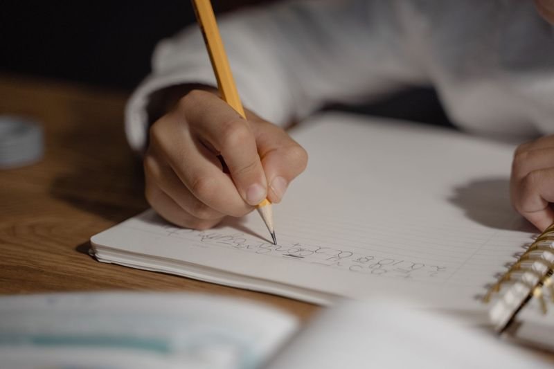 Student taking notes and practising English grammar