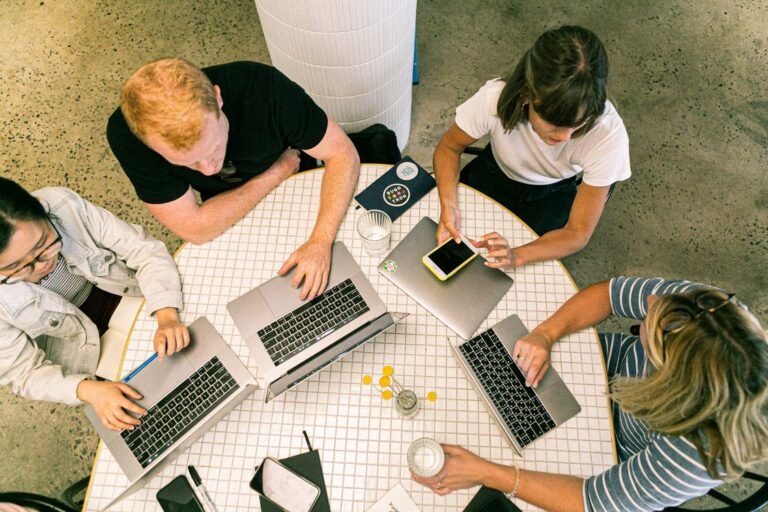 Group of people collaborating on laptops and smartphones