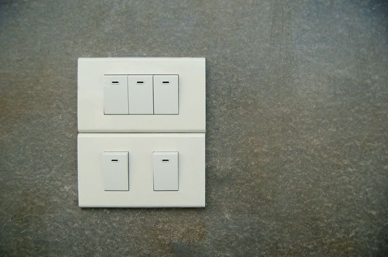 White light switches on a wall — turn on and turn off phrasal verbs in English (turn on turn off 打開 關掉)
